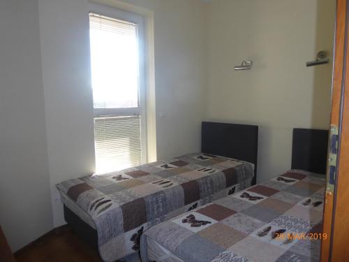 two beds in a room with a window at Kantal Apartamenty Hel in Hel