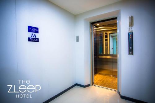 a door in a building with a sign on it at The Zleep Chonburi in Chon Buri