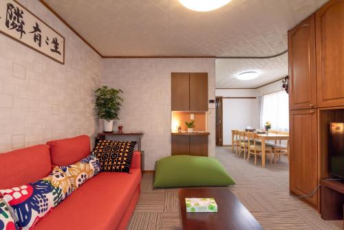 a living room with a red couch and a table at Hong house in Tokyo