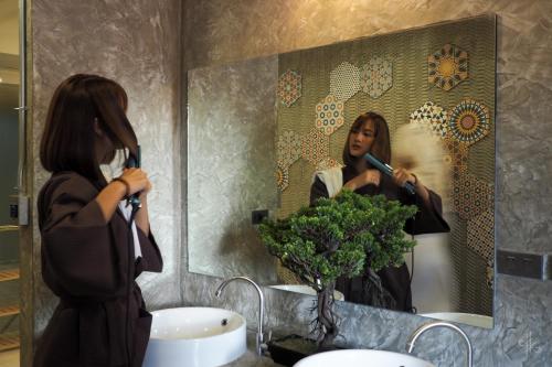 a woman brushing her hair in front of a mirror at TK mansion Hat Yai in Hat Yai