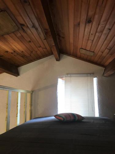 une chambre avec un grand lit avec une fenêtre dans l'établissement Gîte Aghja suttana l'incantu, à Santa-Lucia-di-Mercurio