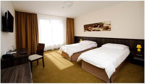 a hotel room with two beds and a television at Hotel Mariana Gaborika in Trenčín