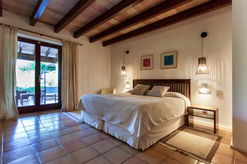 ein Schlafzimmer mit einem Bett und einem großen Fenster in der Unterkunft Agroturismo Ses Arenes in Colonia Sant Jordi