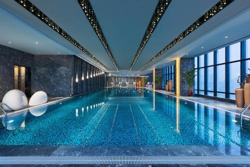 a swimming pool in a building with a large pool at Wanda Realm Jiangmen in Jiangmen