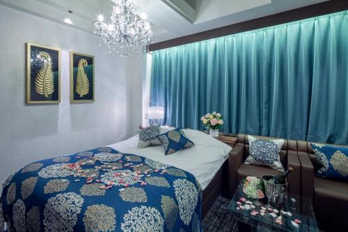 a bedroom with a bed and a chandelier at Restay Hiroshima (Adult Only) in Hiroshima