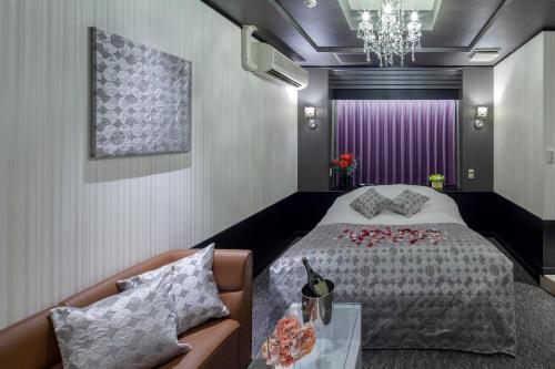 a bedroom with a large bed and a purple curtain at Restay Hiroshima (Adult Only) in Hiroshima