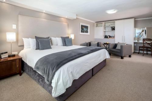 a large bedroom with a large bed and a chair at Cliff Lodge in Gansbaai