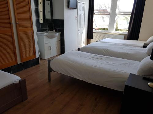 ボーンマスにあるBoscombe Reef Hotelのベッド2台とシンク付きのホテルルームです。