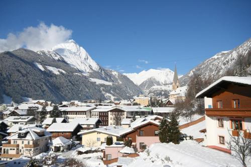 a town covered in snow with mountains in the background at Ferienhaus Sonnenhang in Matrei in Osttirol