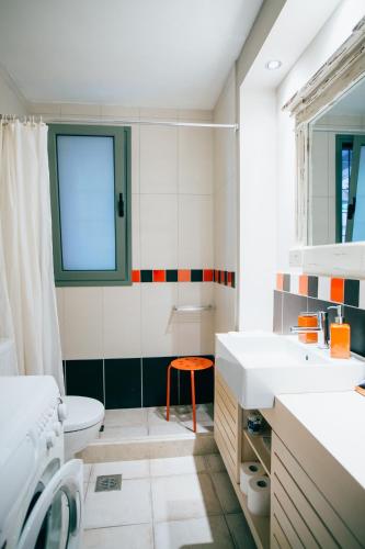 a bathroom with a toilet sink and a window at La Casa Rossa in Agios Nikitas