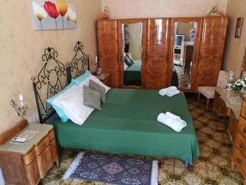 ein Schlafzimmer mit einem grünen Bett und einem Spiegel in der Unterkunft Nice House wifi free bici free in Avola