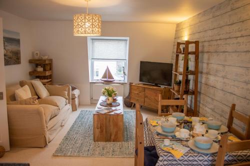 a living room with a couch and a tv at The Beach House Holiday Apartments in Eastbourne