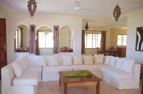 a living room with a white couch and a table at The Sands Beach Resort in Bwejuu