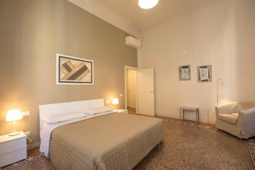 a bedroom with a bed and a chair at Regis Condo in Siena
