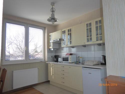 a kitchen with white cabinets and a white appliances at Kantal Apartamenty Hel in Hel