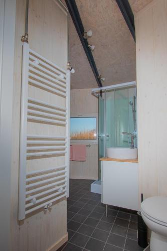 a bathroom with a shower and a sink and a toilet at Dobberhuisje in Nieuwkoop