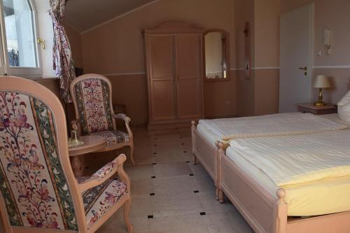 a bedroom with a bed and two chairs at Gästehaus Barese in Bad Münder am Deister