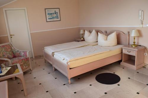 a bedroom with a bed with pillows and a chair at Gästehaus Barese in Bad Münder am Deister