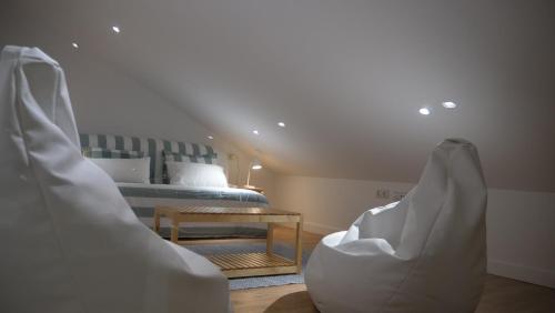 a bedroom with a bed and a table and chairs at Casiñas Mariñeiras (Taberna Vella) in Portosin