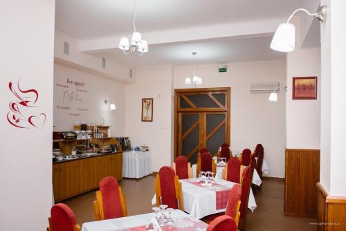 a restaurant with tables and chairs in it at Hotel Iris in Tîrnăveni