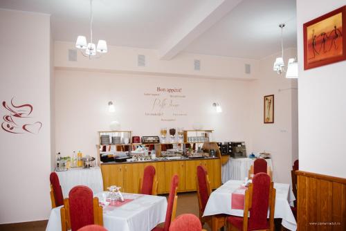 a restaurant with tables and chairs and a counter at Hotel Iris in Tîrnăveni