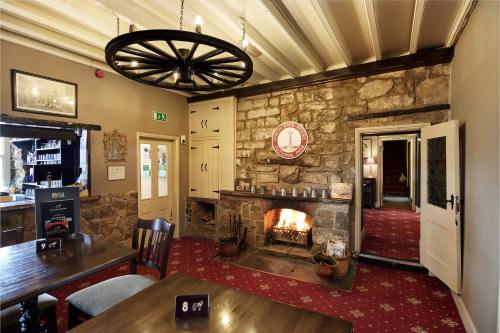 a living room with a stone fireplace and a table at White Horse Farm Inn in Pickering