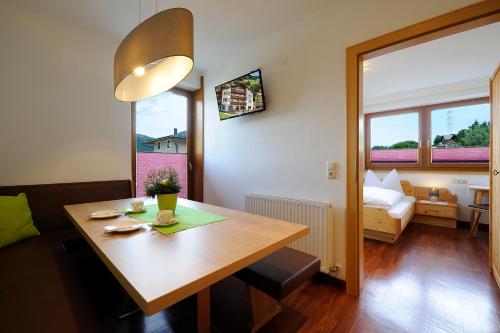 a room with a table and a bedroom with a bed at Pension Edelweiß in Sankt Johann im Pongau