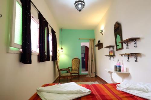 1 dormitorio con paredes verdes y blancas y 1 cama en Dar Zerhoune, en Moulay Idriss