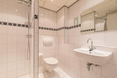 een witte badkamer met een wastafel en een toilet bij New West Inn Amsterdam in Amsterdam
