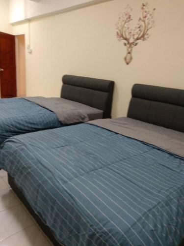 two beds sitting next to each other in a bedroom at D'Rusa Homestay in Port Dickson