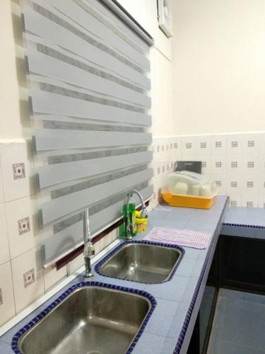a kitchen with a sink and a counter top at D'Rusa Homestay in Port Dickson