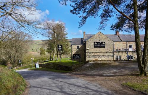 an old stone building on the side of a road at White Horse Farm Inn in Pickering