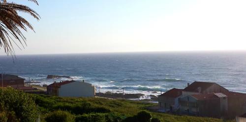 a view of the ocean from a beach with houses at RINCON DO MAR ArenaBlanca in A Guarda