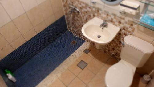 a bathroom with a white toilet and a sink at Color Rainbow Home in Taimali