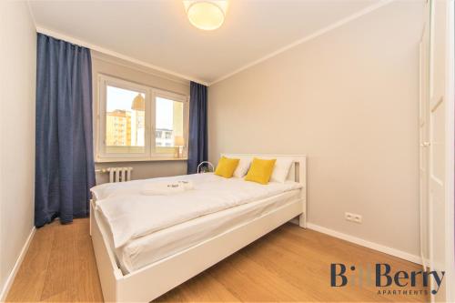 - une chambre avec un grand lit blanc et des oreillers jaunes dans l'établissement Happy - BillBerry Apartments, à Gdynia