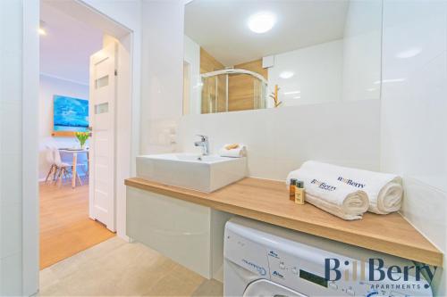 La salle de bains est pourvue d'un lavabo et d'un comptoir avec des serviettes. dans l'établissement Happy - BillBerry Apartments, à Gdynia