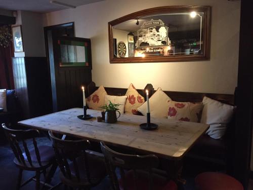 a wooden table with candles on it with a couch at The Blackboys Inn in Framfield