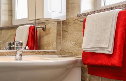 a bathroom with red and white towels and a sink at Hotel ZRINSKI in Koprivnica