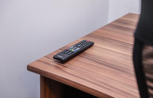 a remote control sitting on top of a wooden table at Hotel ZRINSKI in Koprivnica