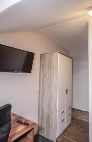 a room with a tv on the wall and a cabinet at Hotel ZRINSKI in Koprivnica