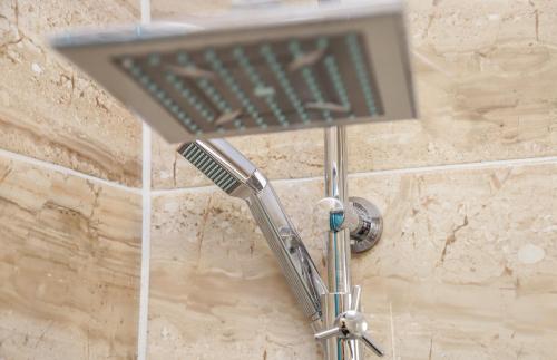 a shower head on a wall in a bathroom at Hotel ZRINSKI in Koprivnica
