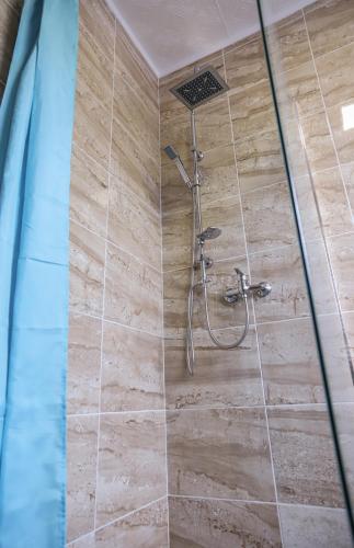 a shower with a shower head in a bathroom at Hotel ZRINSKI in Koprivnica