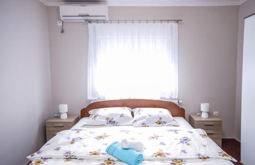 a bedroom with a bed with a flowery bedspread and a window at Hotel ZRINSKI in Koprivnica