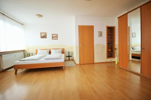 Un dormitorio con una cama y suelo de madera. en Fewo Spiaggia - Gästehaus Kön, en Zeltingen-Rachtig