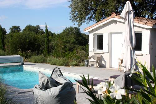 ein Haus mit Swimmingpool neben einem Gebäude in der Unterkunft Au Coin des Cerisiers in Montclus