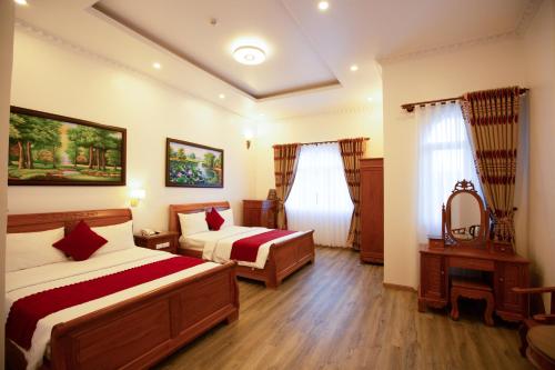 a hotel room with two beds and a mirror at Dragon King 1 Hotel in Da Lat