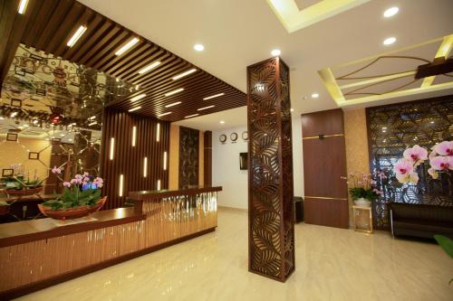 a lobby of a hotel with a large wooden pillar at Dragon King 1 Hotel in Da Lat