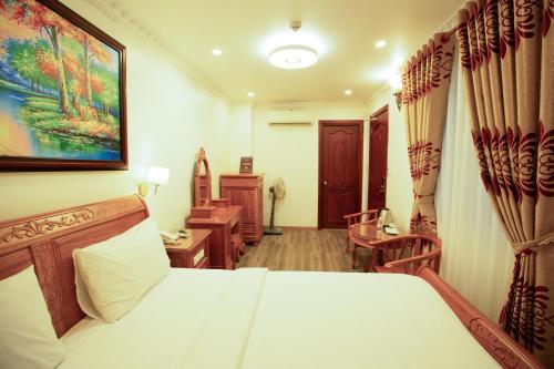 a bedroom with a bed and a desk and a room at Dragon King 1 Hotel in Da Lat