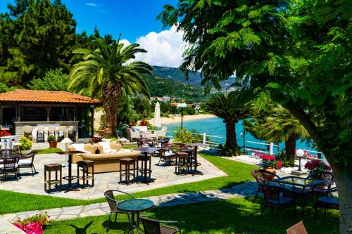 a patio with tables and chairs next to a body of water at Villa Romantica Hotel in Paleo Tsifliki