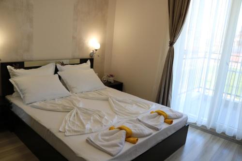 a bedroom with a bed with towels on it at сем. Павлови in Obzor